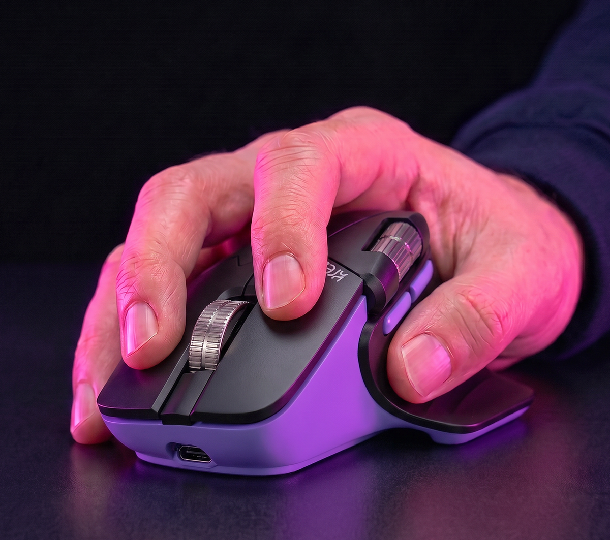 A hand resting on the Kreo Axis mouse with its thumb rest