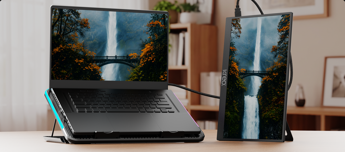 Laptop raised on the Taiga cooler beside a portable monitor on a desk